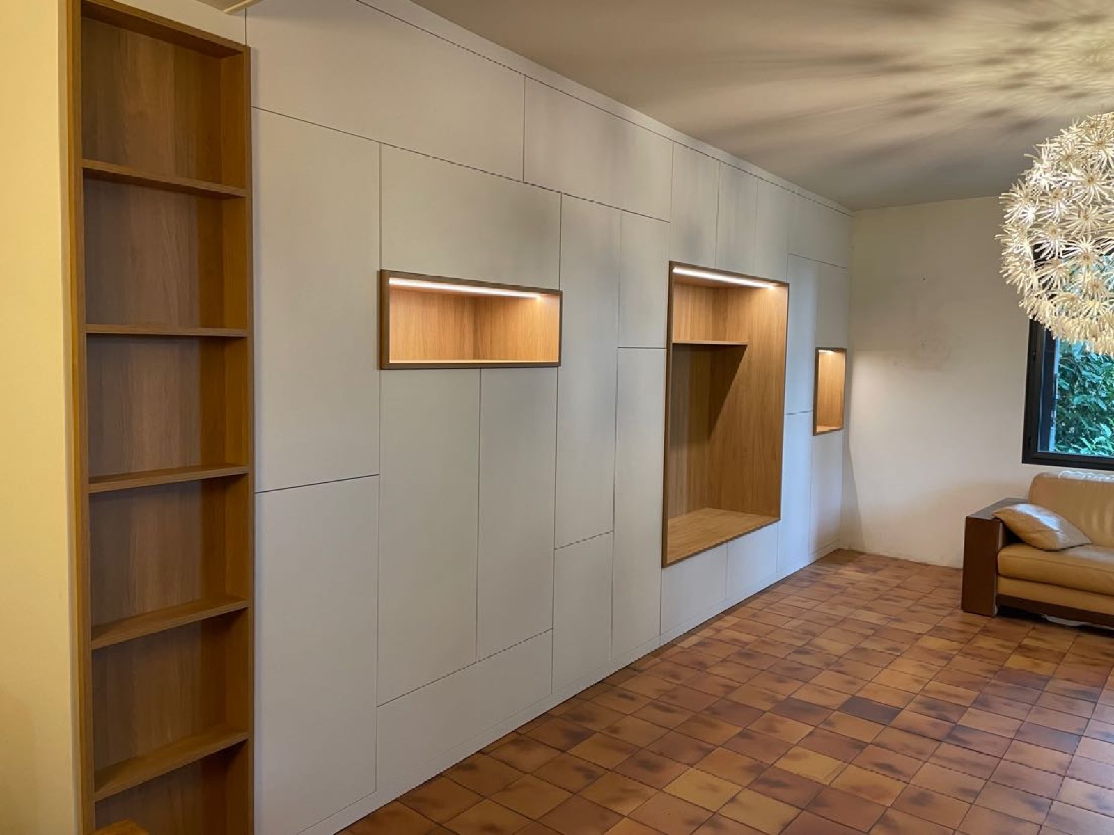 Ensemble de rangements muraux sur mesure avec niches en chêne éclairées